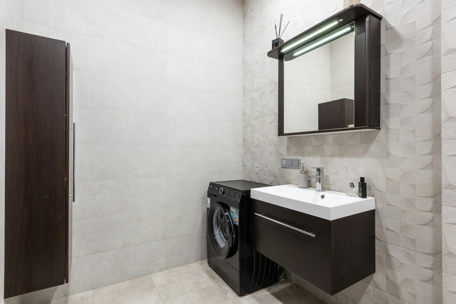 Sleek and stylish bathroom featuring a washing machine and contemporary sink setup.